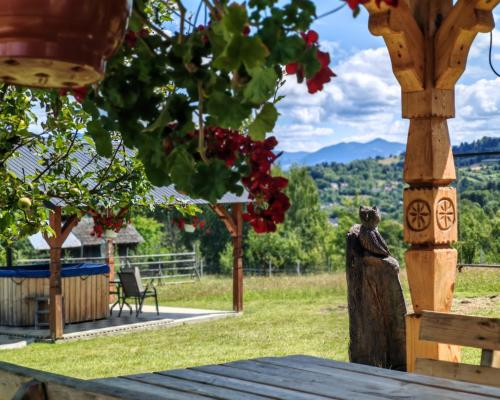a wooden table with a view of a field with flowers at Cabana Maramures Landscape in Moisei