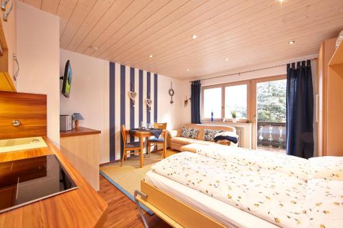 a bedroom with a bed and a living room at Frickenblick Lounge & Sauna in Farchant