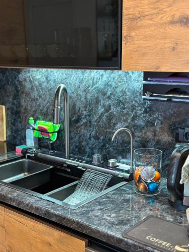 a kitchen sink with two faucets on a counter at Lux Apartman Leša in Vrdnik