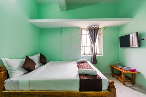 a bedroom with a bed in a room with green walls at B2N Hotels Near Sri Ramachandra Hospital Porur in Chennai