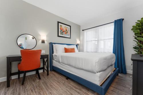 a bedroom with a bed and a desk and a mirror at Volcano View 2 Bed 2 Bath Condo with Balcony in Orlando