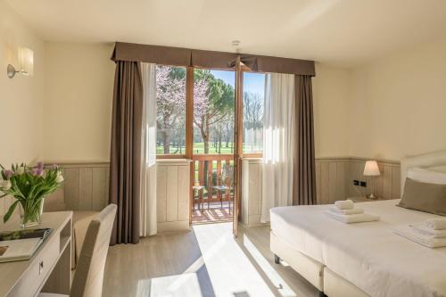 ein Hotelzimmer mit Bett und Balkon in der Unterkunft Hotel Golf Inn in Lignano Sabbiadoro