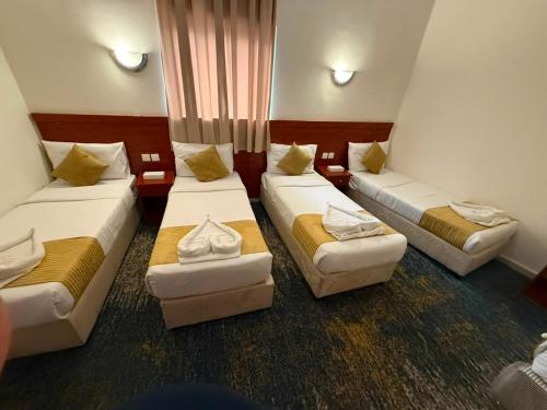 a room with three beds in a room at فندق سما المشاعر اجياد Sama Al Masher Ajyad in Ajyad