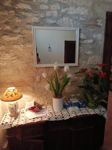 a table with a mirror and a lamp on it at B&B - Casale di Mary in Contigliano