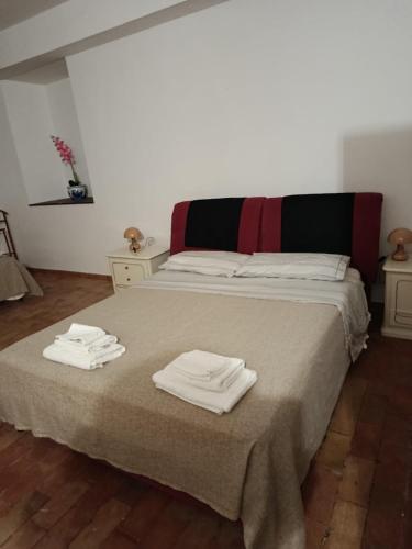 a bedroom with a bed with two towels on it at B&B - Casale di Mary in Contigliano