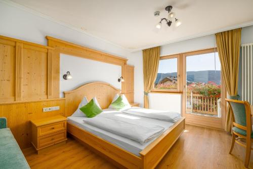 a bedroom with a bed and a large window at Residence Diana Apartment 302 in Terento