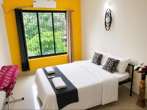 a bedroom with a bed with yellow walls and a window at Regal by the bay in Varca