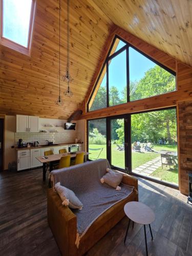 a living room with a couch and a large window at Cabana ONYX Baile Olanesti in Băile Olăneşti