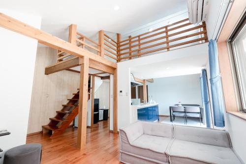 a living room with a staircase and a couch at 1日1組限定 一棟貸し Japanese Traditional House Three Field Tamba-Sasayama in Sasayama
