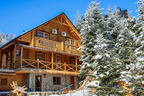 a log cabin in the snow with trees at Karpaty Migovo in Migovo