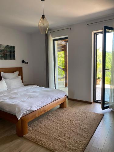 a bedroom with a bed with white sheets and a rug at Stone Apartment with sauna Sinaia in Sinaia