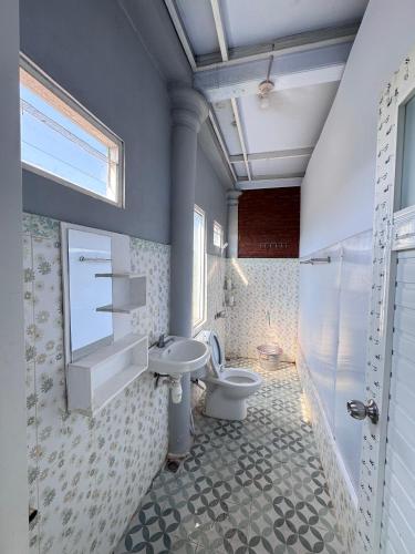 a bathroom with a toilet and a sink and a window at Georium Dunia in Prambanan