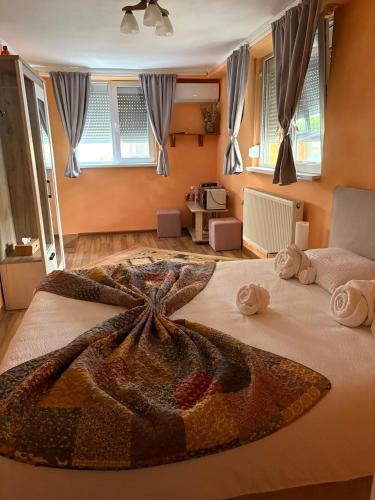 a bedroom with a large bed with towels on it at Casa Maya with private parking in Oradea