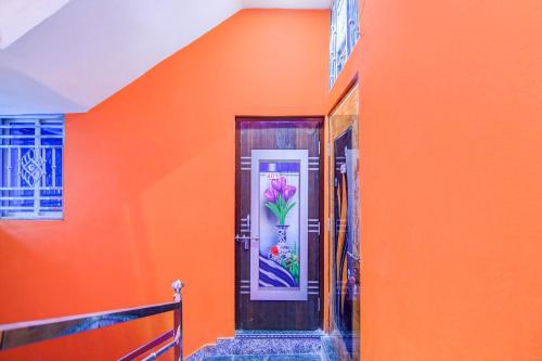 an orange wall with a door with a flower on it at Hotel O Elegant Stay CDA in Cuttack