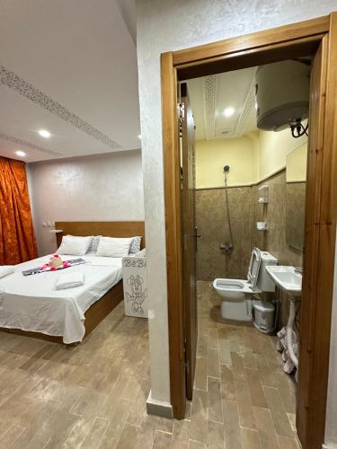 a bedroom with a bed and a toilet and a sink at hotel el amri akchour in Akchour