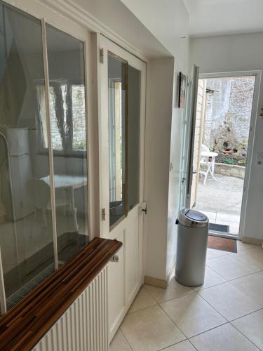 a hallway with a glass door and a trash can at Le Cepyo in Saint-Quentin