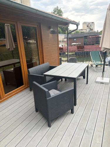 a wooden deck with a table and chairs on it at Vasilisa Luxury River House in Pančevo