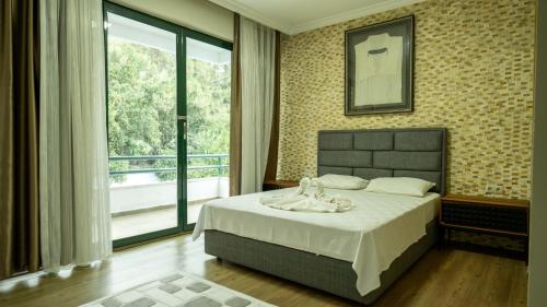 a bedroom with a bed and a large window at Villa Diva in Kemer