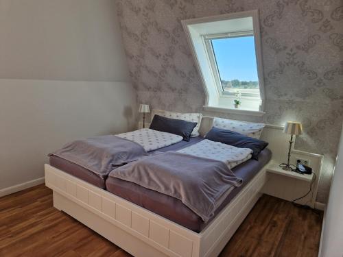 a bedroom with two beds and a window at Suite in Nieblum - Martina Christiansen in Nieblum