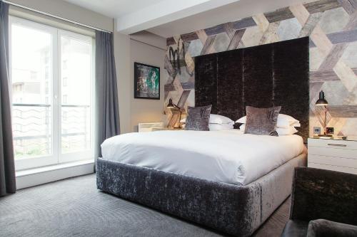 a bedroom with a large bed and a large window at Malmaison Edinburgh in Edinburgh