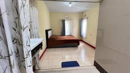 a bathroom with a bed and a sink in a room at Pildacil in Garut