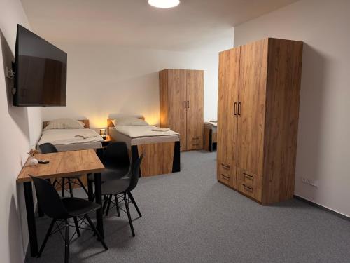a room with two beds and a table and chairs at Kolík Apartmány in Bohumín