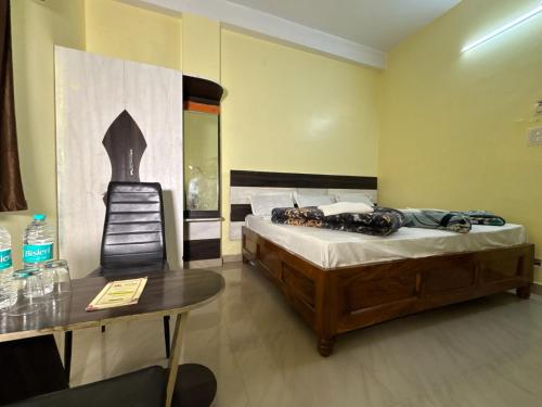 a bedroom with a bed and a table and a chair at Hotel Radiation Deoghar in Deoghar