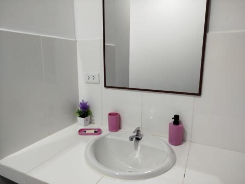 a bathroom sink with a mirror and a pink soap dispenser at BACHÍG Hospedaje in Moyobamba