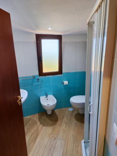 a bathroom with two toilets and a sink and a window at A Chera Via in Laureana Cilento