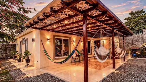 a house with a porch with a hammock on it at Nandos Places in Puerto Barrios