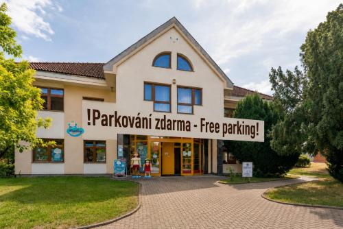 a building with a sign that reads parkani karma free parking at Apartmán v Poděbradech in Poděbrady