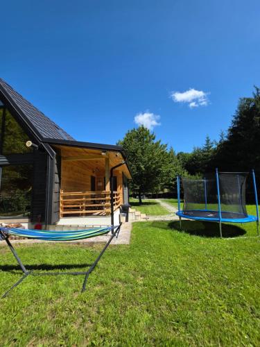 a house with two trampolines in the grass at Cabana ONYX Baile Olanesti in Băile Olăneşti
