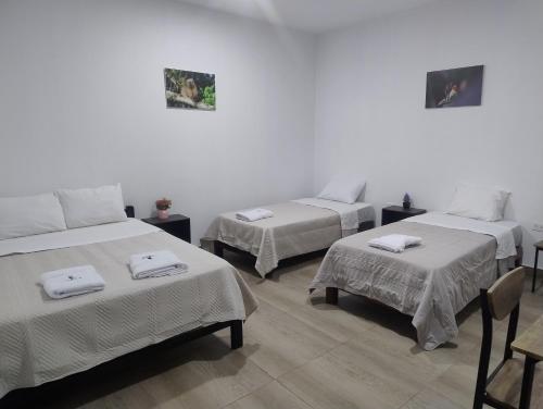 a room with three beds with towels on them at BACHÍG Hospedaje in Moyobamba