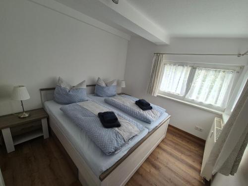 a bedroom with a large bed with blue pillows at Antonios Hüttenzauber in Oberhof