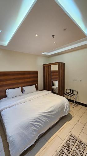 a bedroom with a large bed with a wooden headboard at فيولورين سويتس in Al Baha
