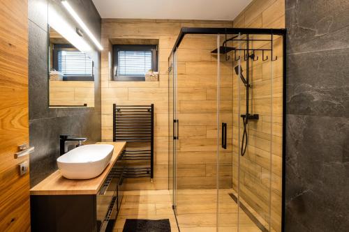 a bathroom with a sink and a shower at Chata Alexia Oravice in Vitanová