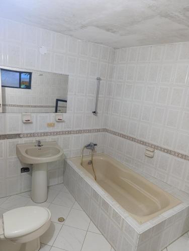 a bathroom with a tub and a toilet and a sink at Palma Paraíso Hotel in Melgar