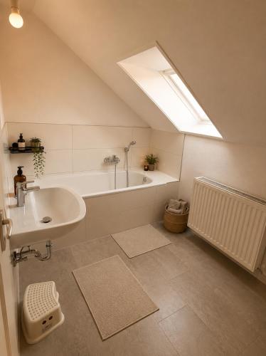 a bathroom with a sink and a bath tub at Moderne Dachgeschosswohnung in Kirchlengern