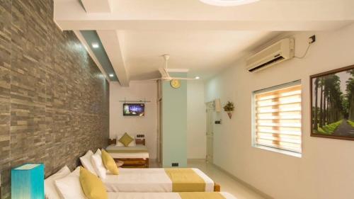 a bedroom with two beds and a brick wall at Shalom Residence Kandy in Kandy