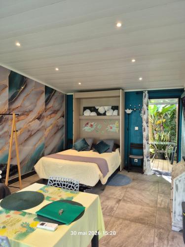 a bedroom with two beds and a painting on the wall at La familiale in Salazie