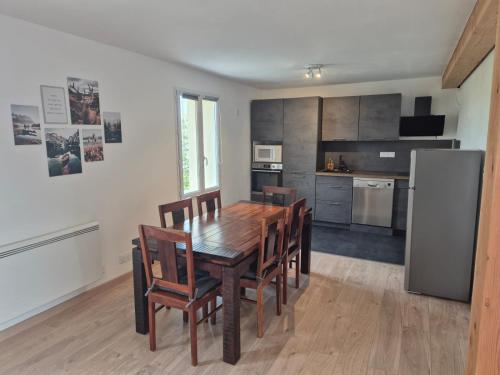 a kitchen and dining room with a wooden table and chairs at Chez steph studio in Saint-Germain-Nuelles
