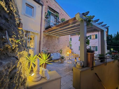 a patio of a building with a pergola at Residenza d'Epoca CAVALIERE - Romantic Rooms in Bibbona