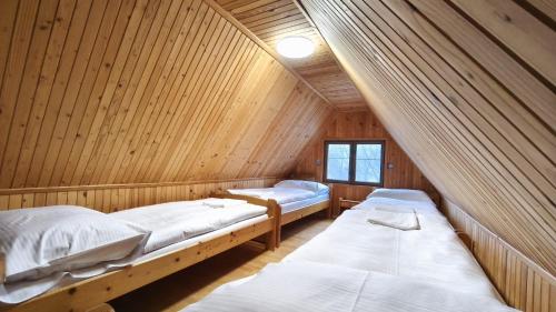 a room with two beds in a wooden cabin at Chata Kopánka in Moderštôlňa