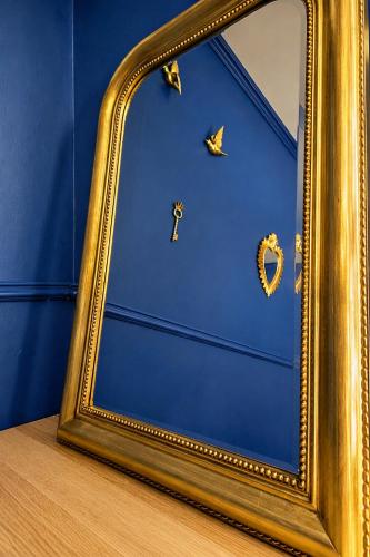 a gold framed mirror sitting on top of a table at L'échappée Seine - Idéalement situé in Barentin