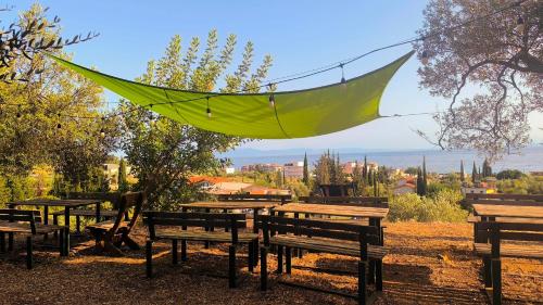 a green hammock hanging over a bunch of benches at Camping Himara in Himare