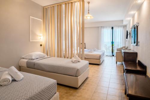 una camera d'albergo con due letti e una scrivania di Ocean Beach Hotel a Skala Potamias