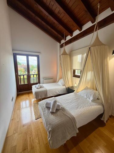 a bedroom with two beds and a large window at La casa de Nino in Cabanzón