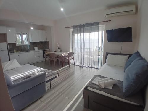 a living room with a couch and a dining room at Panorama Palace 1 in Palasë