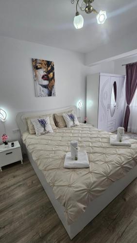 a large bed in a white room with two towels on it at Divine Luxury Rasnov in Râşnov