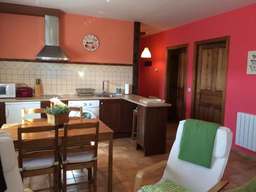 a kitchen with red walls and a table and chairs at La Senda Del Duratón in Sebúlcor
